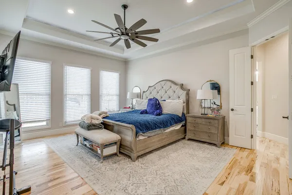 a spacious bedroom with a large bed and a chandelier