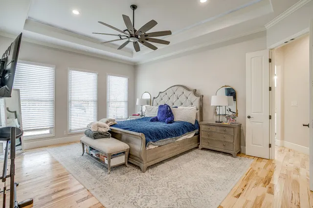 a spacious bedroom with a large bed and a chandelier