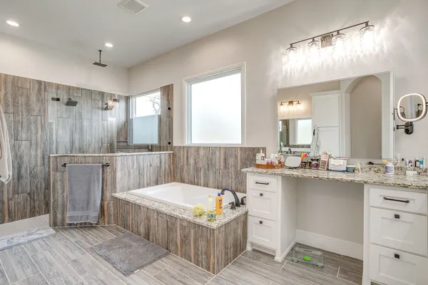 a bathroom with a tub a sink and a mirror