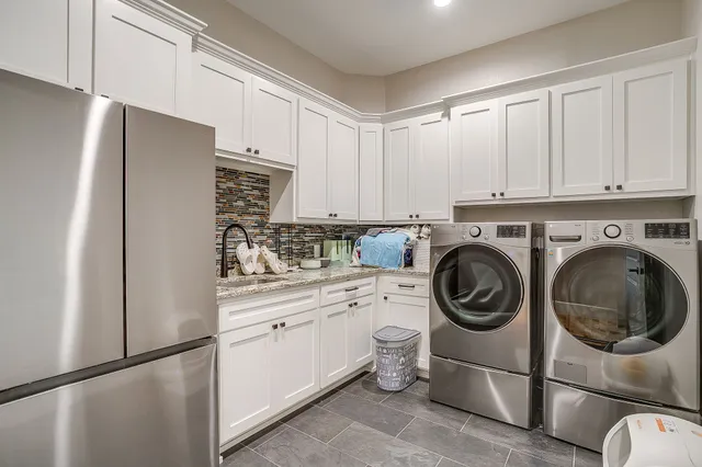a kitchen with stainless steel appliances white cabinets and a refrigerator