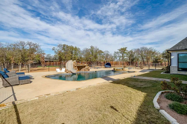 a swimming pool with outdoor seating and yard