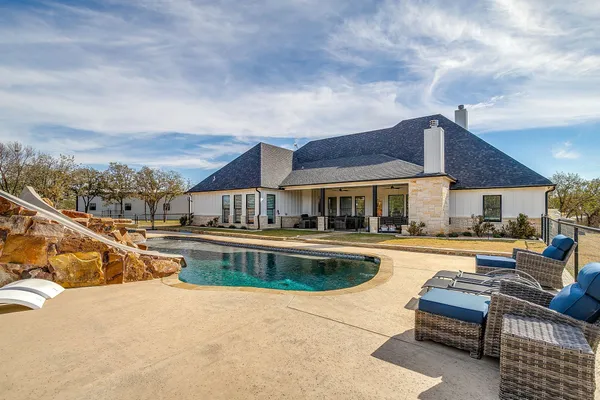 a view of a house with pool and a yard