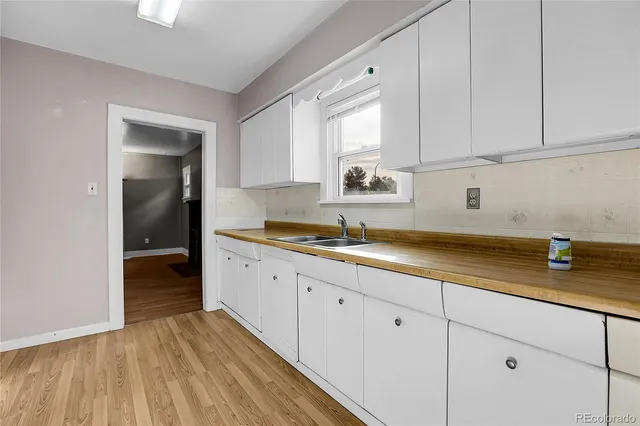a kitchen with granite countertop white cabinets and a sink