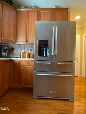 a kitchen with stainless steel appliances granite countertop a refrigerator and a stove top oven