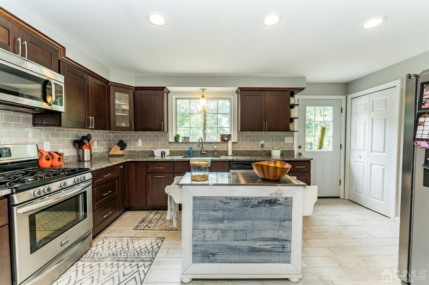 1077 Cranbrook Road Union, NJ 07083 - Photo 11 of 37 a kitchen with stainless steel appliances granite countertop a stove a sink and a microwave