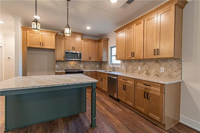 a kitchen with stainless steel appliances granite countertop a stove a sink and a refrigerator