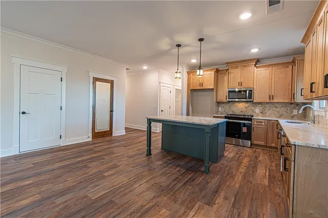 a kitchen with a sink a microwave a stove and refrigerator