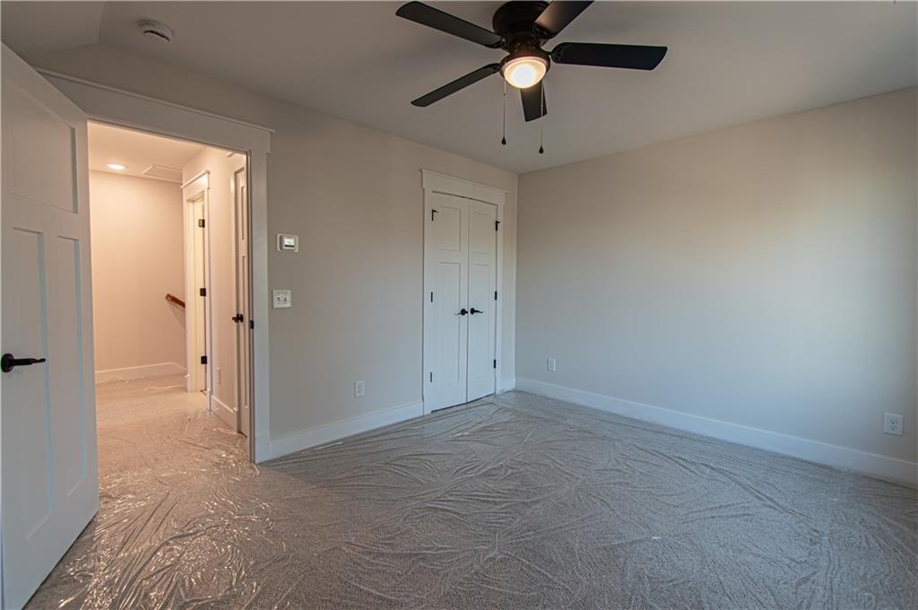 386 Mulberry Circle Jasper, GA 30143 - Photo 38 of 46 an empty room with a ceiling fan and carpet