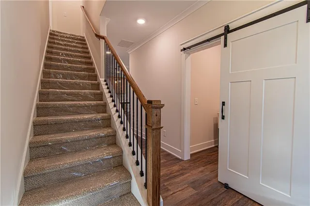 a view of a hallway with wooden floor and entryway
