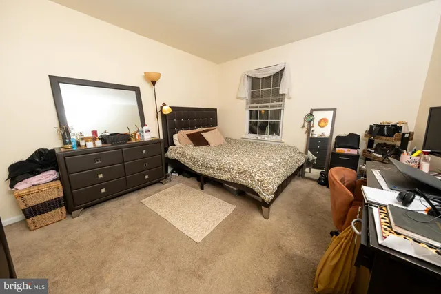 a bedroom with a bed and dresser with mirror