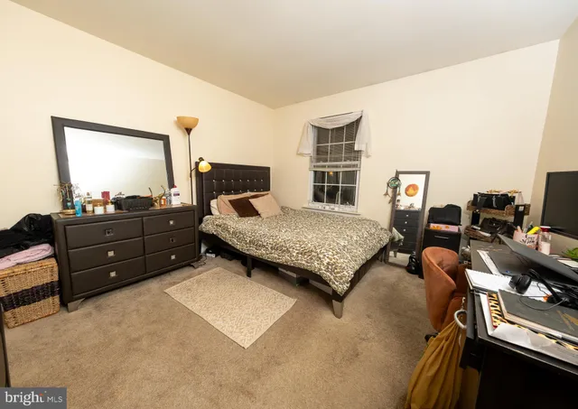 a bedroom with a bed and dresser with mirror