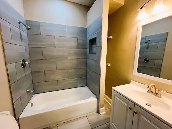 a bathroom with a tub sink and mirror