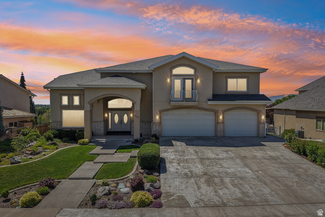 220 East Ridge Road Orem, UT 84057 - Photo 51 of 52 Stucco exterior with stone accents, arched entry, two-car garage, and a second-story balcony