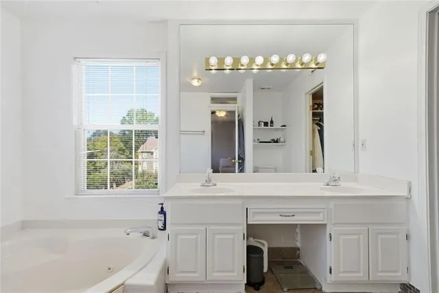 a bathroom with a tub sink and mirror