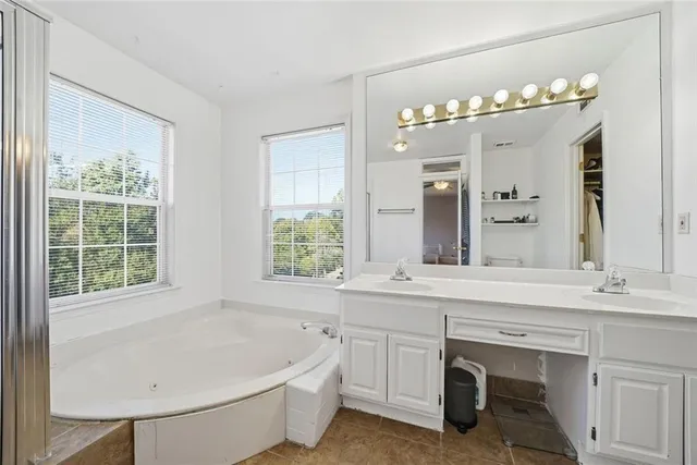 a bathroom with a tub sink shower and mirror