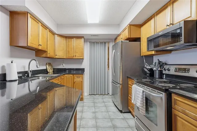 a kitchen with stainless steel appliances granite countertop a sink dishwasher stove and cabinets