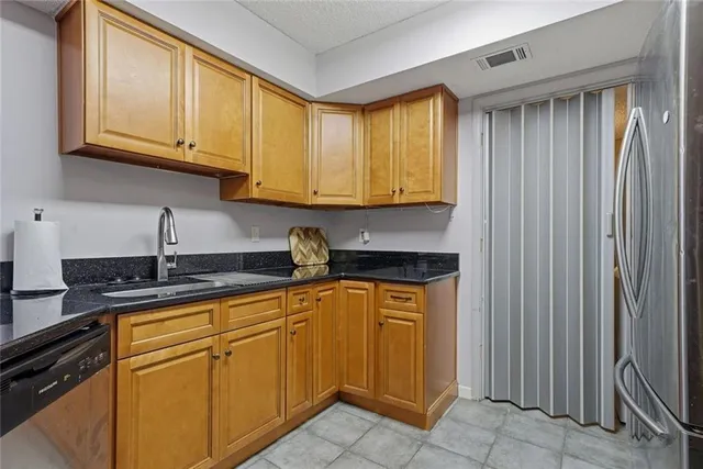 a kitchen with stainless steel appliances granite countertop a sink and a white cabinets