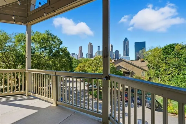 a view of a balcony with wooden floor & fence