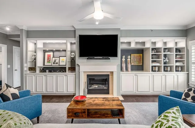 a living room with furniture a flat screen tv and a fireplace
