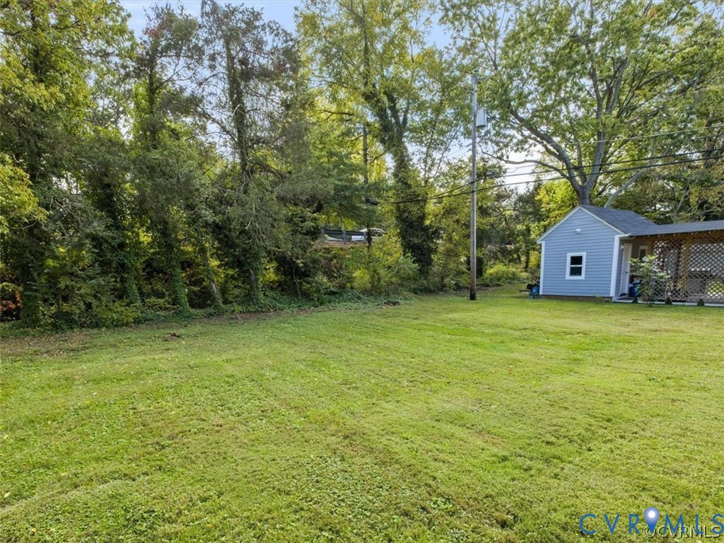 8719 Mapleton Road Henrico, VA 23229 - Photo 20 of 20 Expansive grassy area with a light blue detached s