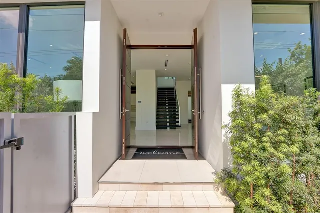 a living room with furniture large windows and flat screen tv