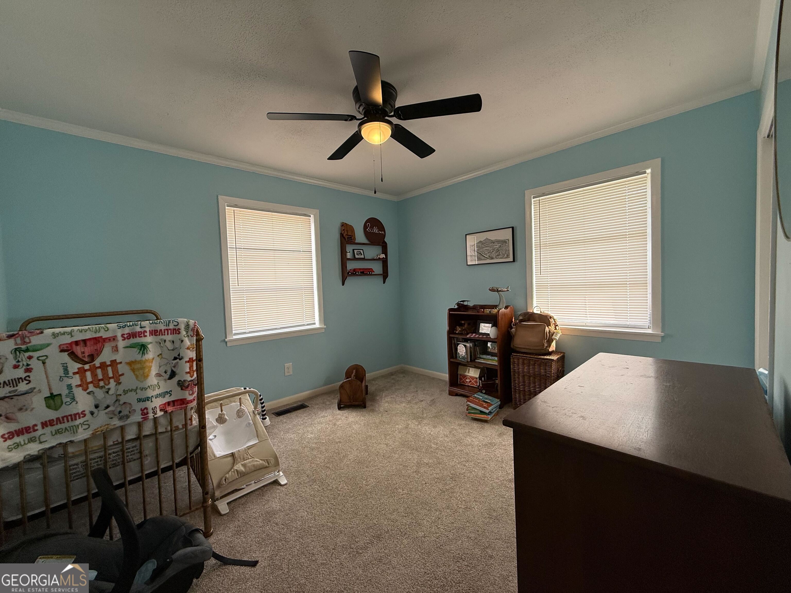 804 Betty Street Sandersville, GA 31082 - Photo 12 of 21 a bedroom with bed and a chandelier