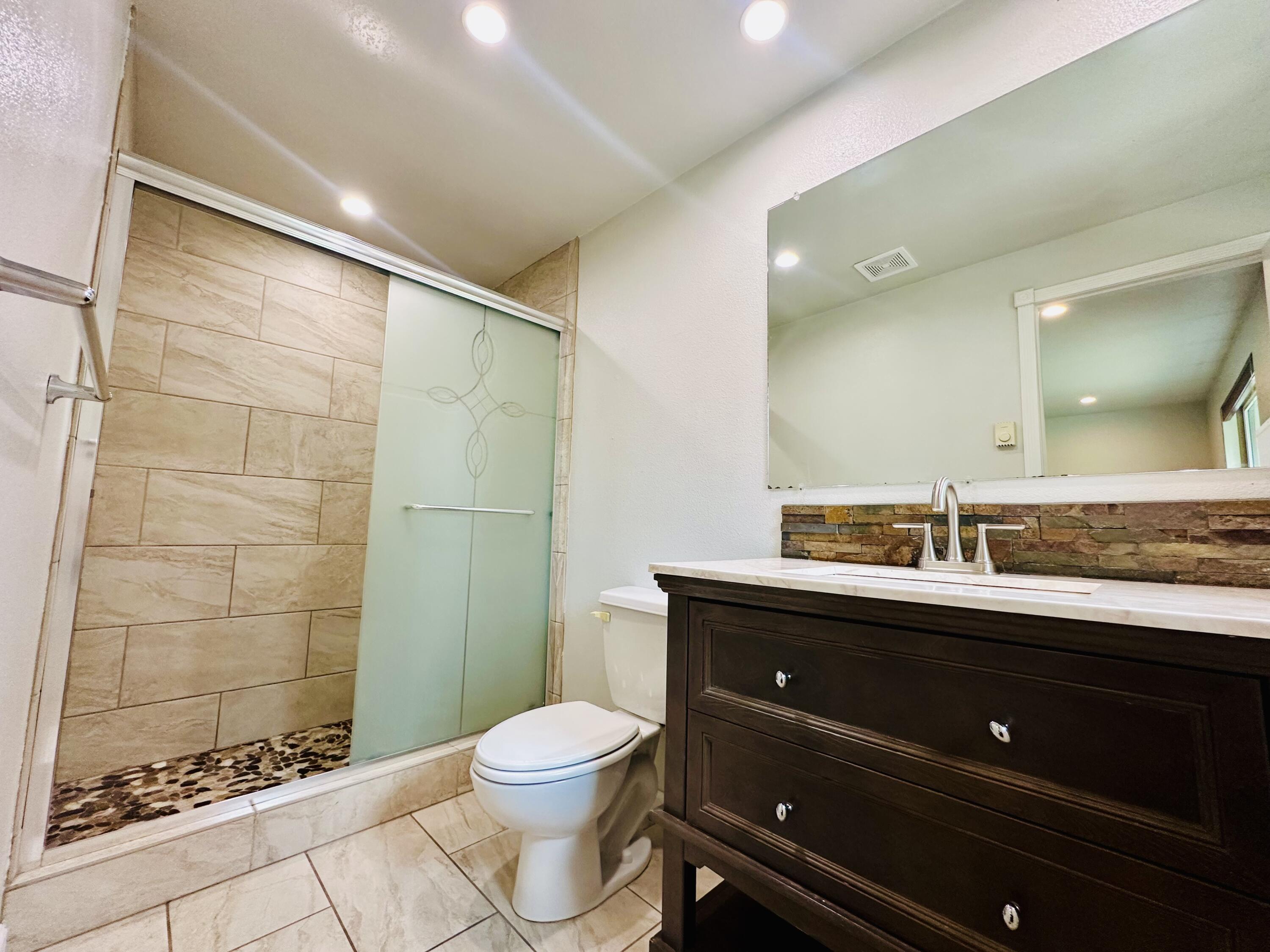 16524 Fieldcrest Road Klamath Falls, OR 97603 - Photo 33 of 58 a bathroom with a granite countertop toilet a sink and a mirror