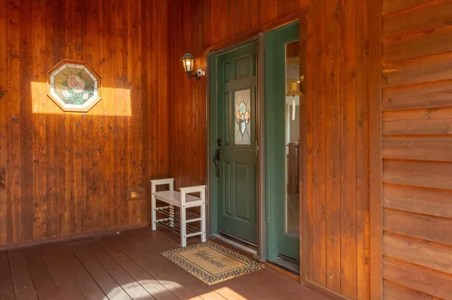 a view of a hallway with wooden floor and a chair