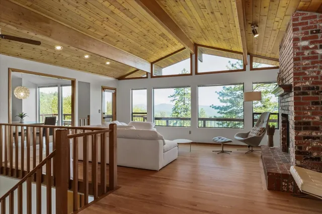a living room with furniture floor to ceiling window and wooden floor
