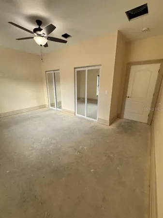 a view of an empty room with a ceiling fan