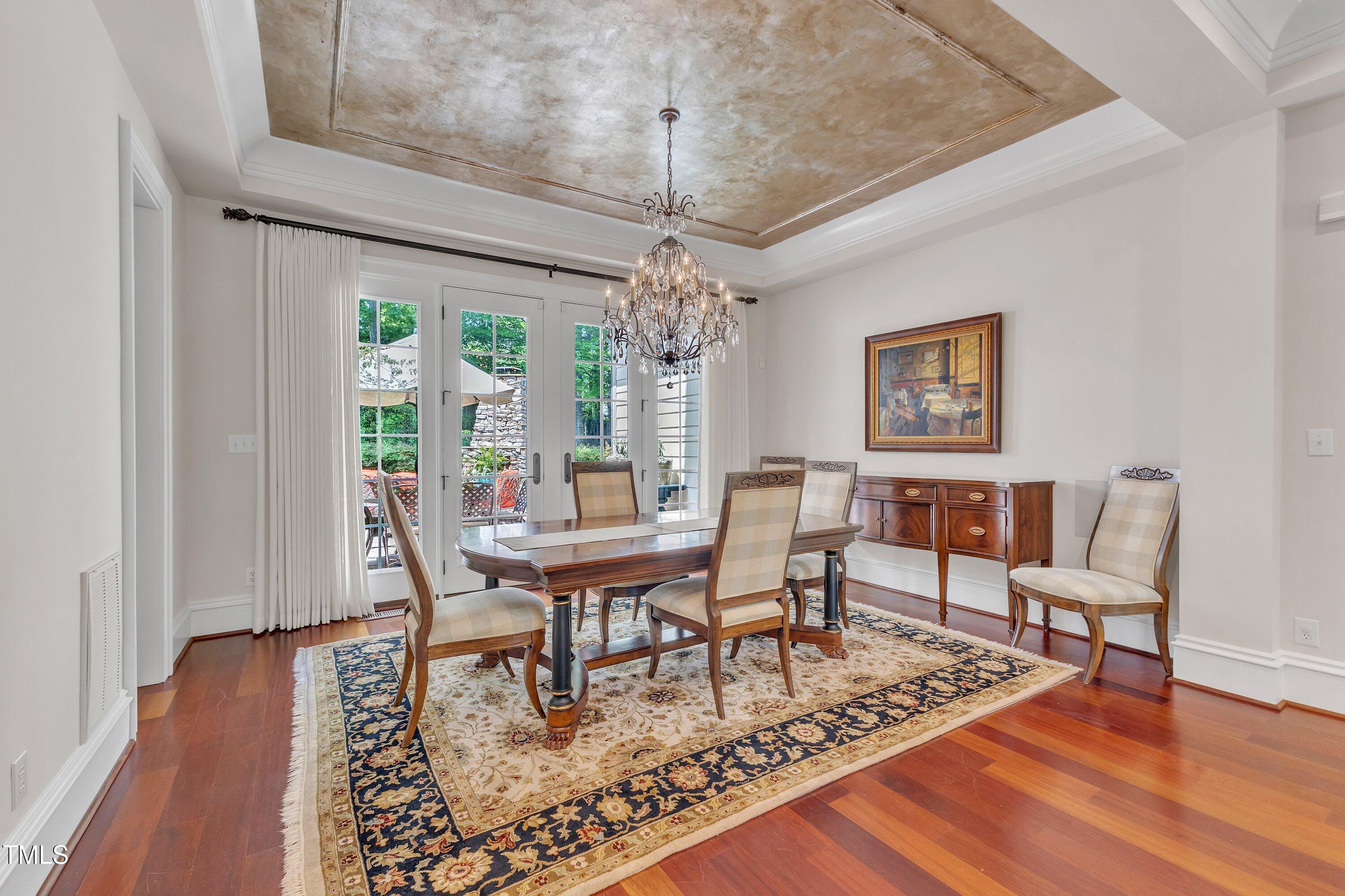 2117 Buckingham Road Raleigh, NC 27607 - Photo 10 of 82 a dining room with wooden floor a chandelier a wooden table and chairs
