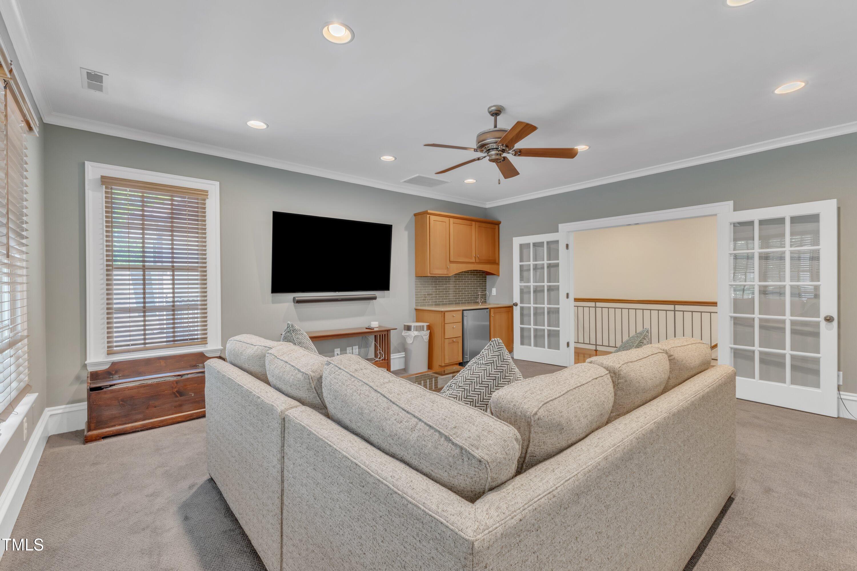 2117 Buckingham Road Raleigh, NC 27607 - Photo 42 of 82 a living room with furniture a ceiling fan and a flat screen tv