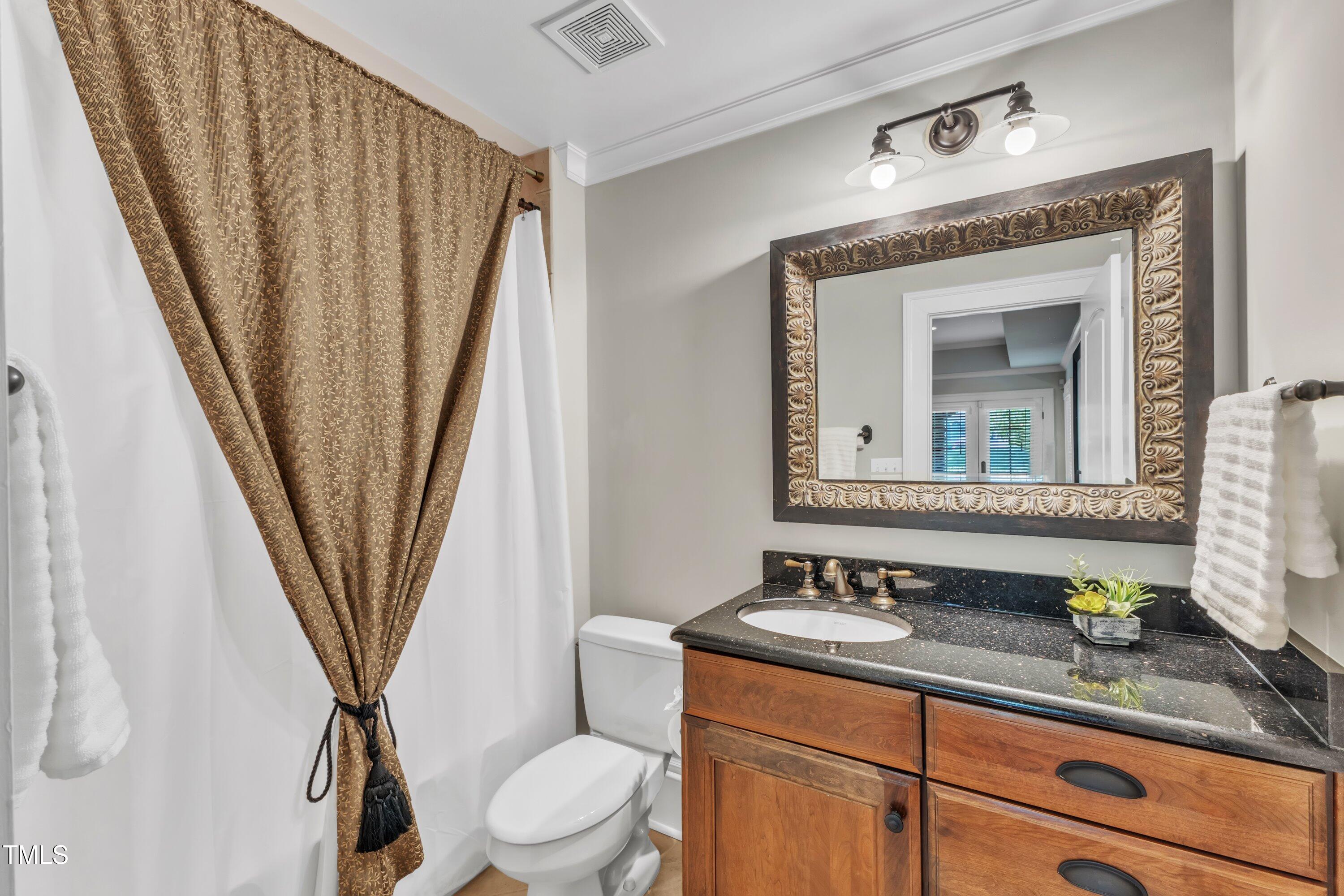 2117 Buckingham Road Raleigh, NC 27607 - Photo 63 of 82 a bathroom with a sink a toilet and a mirror