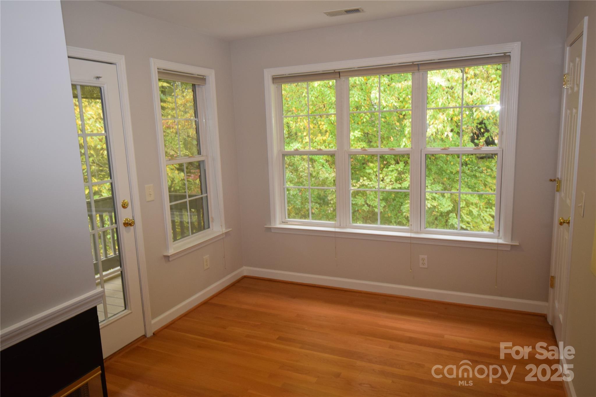 809 Pine Forest Road Charlotte, NC 28214 - Photo 17 of 36 a view of an empty room with wooden floor and a window