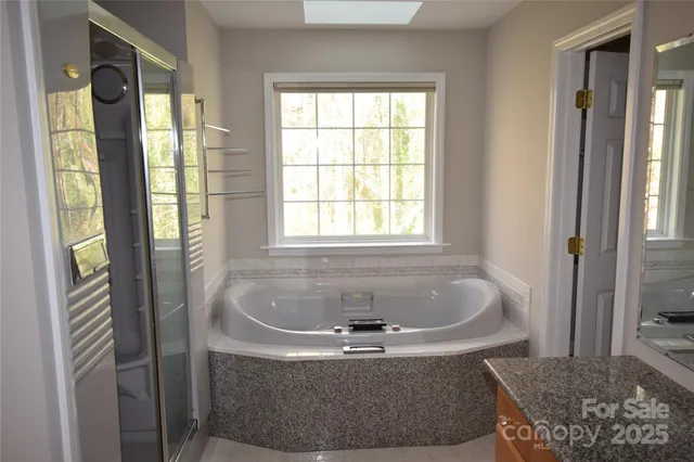 a white bath tub sitting in a bathroom next to a window