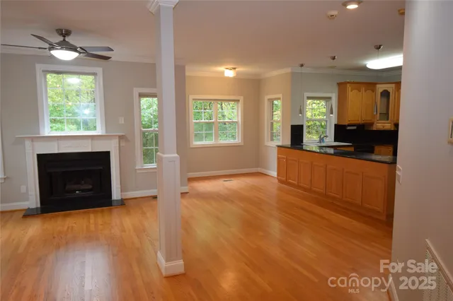 a view of an empty room with window and wooden floor