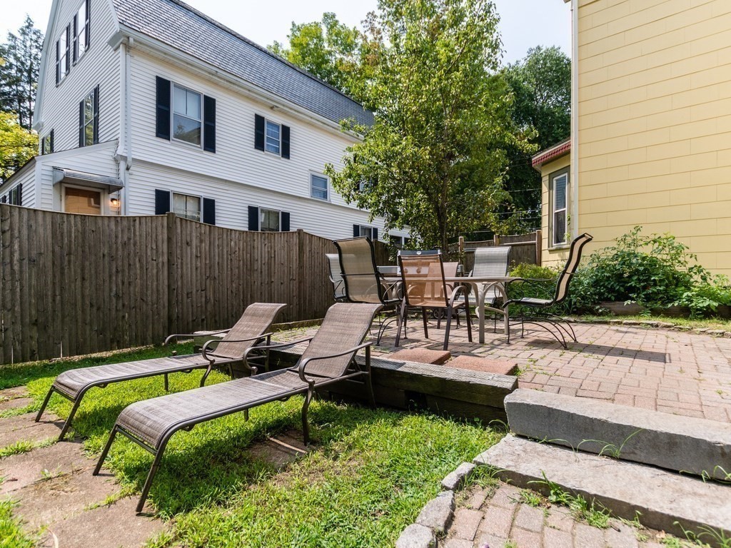 16 Alexander Street Framingham, MA 01702 - Photo 40 of 41 a view of a backyard with chairs potted plants and a wooden bench