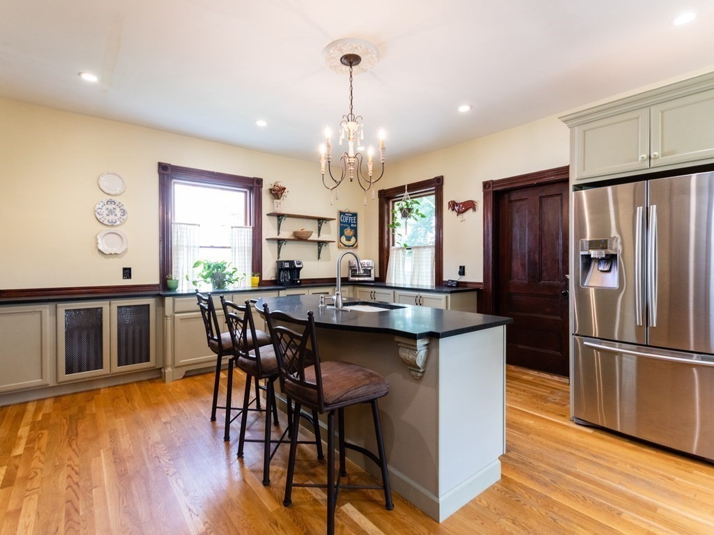 16 Alexander Street Framingham, MA 01702 - Photo 7 of 41 a kitchen with stainless steel appliances granite countertop a kitchen island hardwood floor and a sink