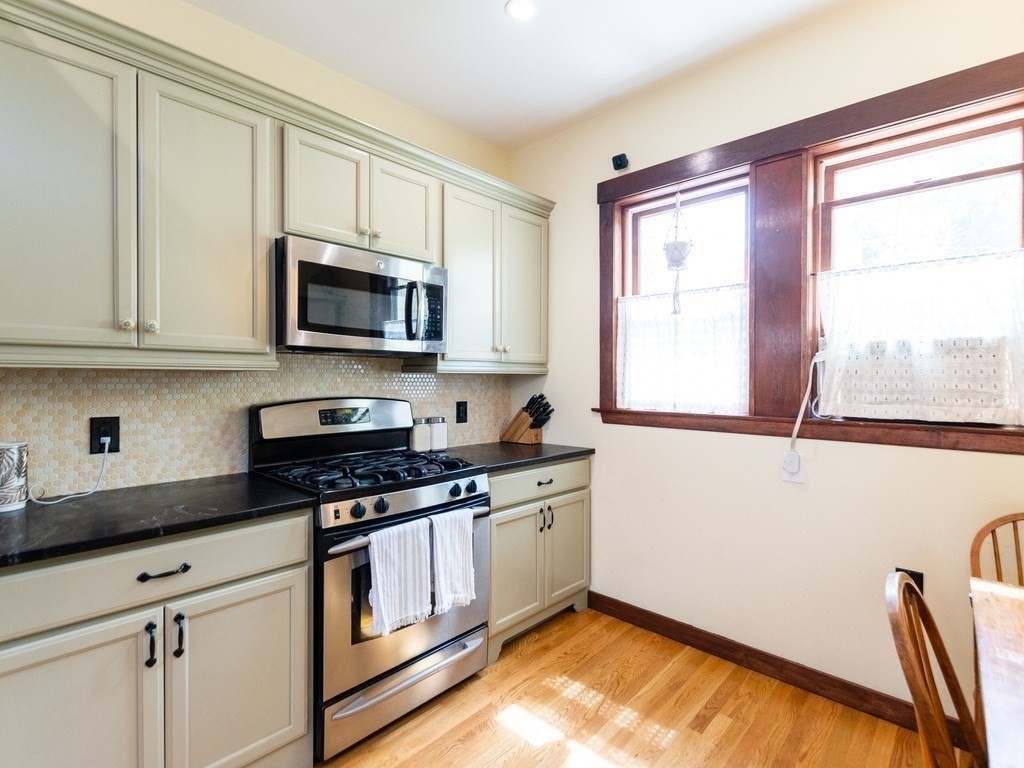16 Alexander Street Framingham, MA 01702 - Photo 10 of 41 a kitchen with granite countertop a stove a sink and a microwave