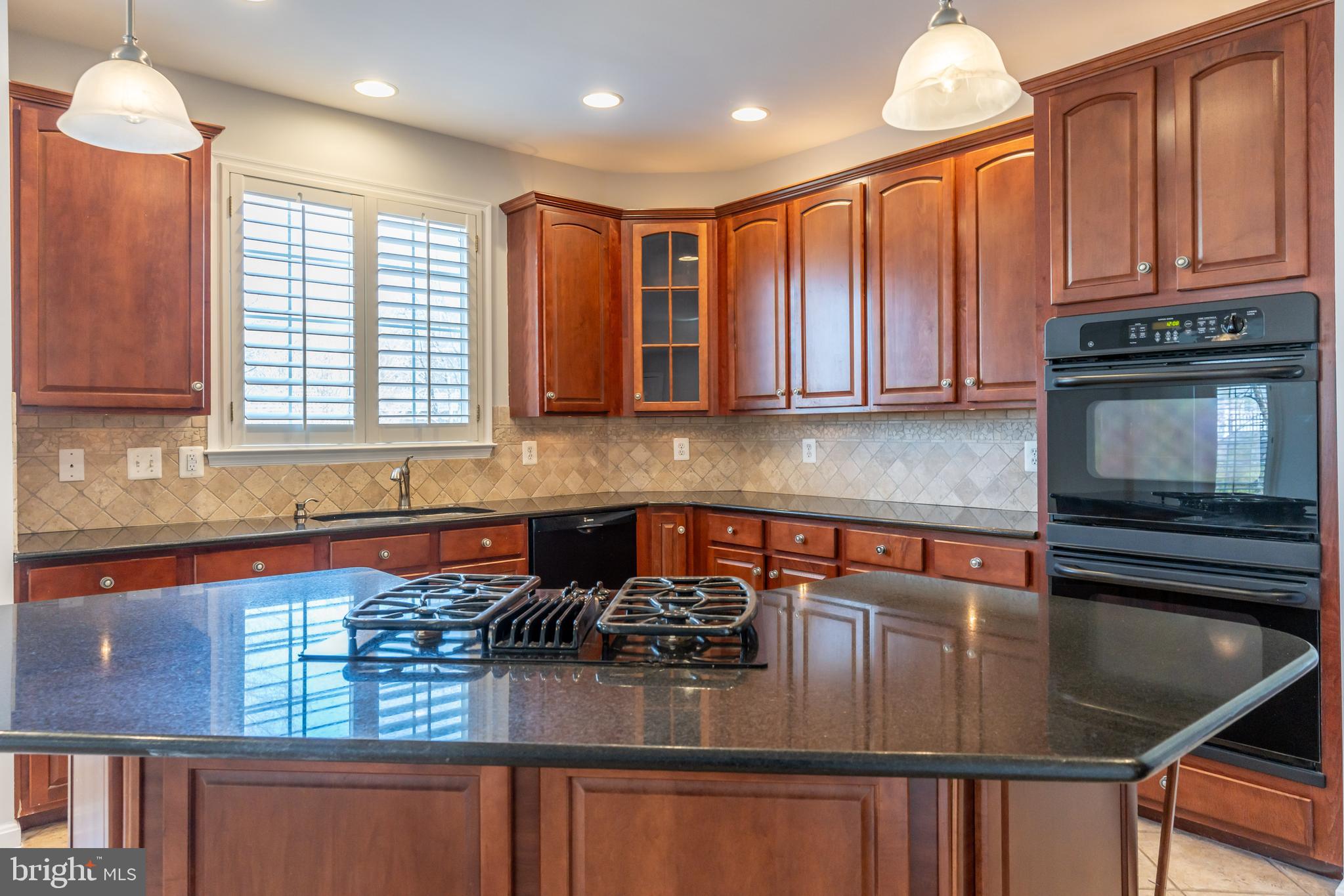 12675 Rushing Creek Court Bristow, VA 20136 - Photo 18 of 49 a kitchen with stainless steel appliances granite countertop a stove a sink and a microwave