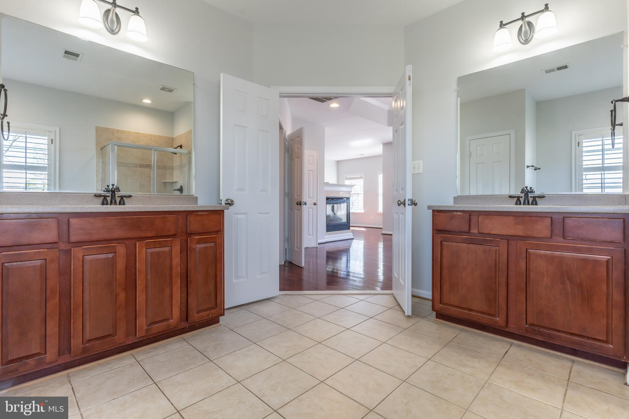 12675 Rushing Creek Court Bristow, VA 20136 - Photo 24 of 49 a spacious bathroom with a granite countertop sink and a mirror