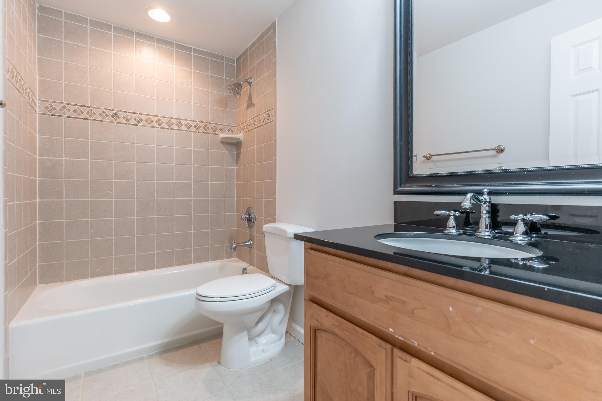 12675 Rushing Creek Court Bristow, VA 20136 - Photo 26 of 49 a bathroom with a granite countertop sink a toilet and bathtub