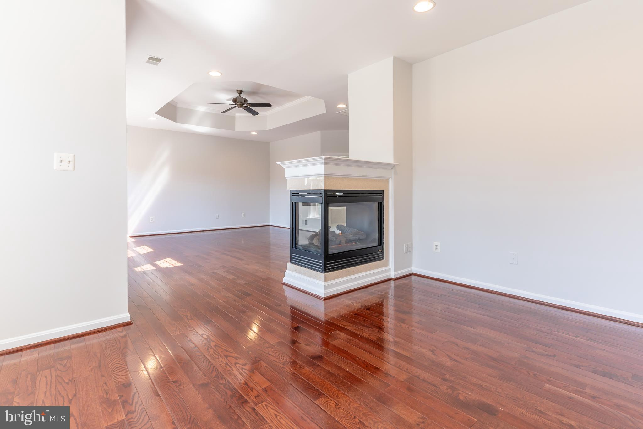 12675 Rushing Creek Court Bristow, VA 20136 - Photo 30 of 49 a view of an empty room with wooden floor and a fireplace