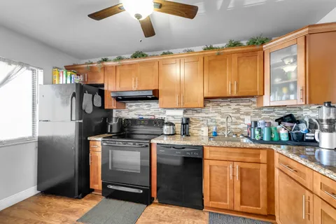 a kitchen with stainless steel appliances granite countertop a stove a sink dishwasher and a refrigerator