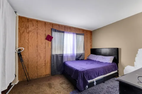 a spacious bedroom with a bed and a mirror