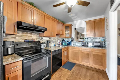 a kitchen with stainless steel appliances granite countertop a stove a sink and a microwave