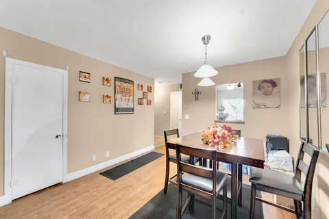 a dining room with furniture a chandelier and wooden floor