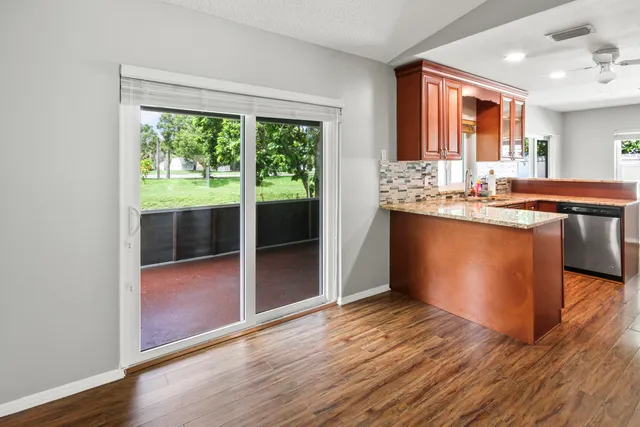 a view of kitchen with granite countertop window and wooden floor