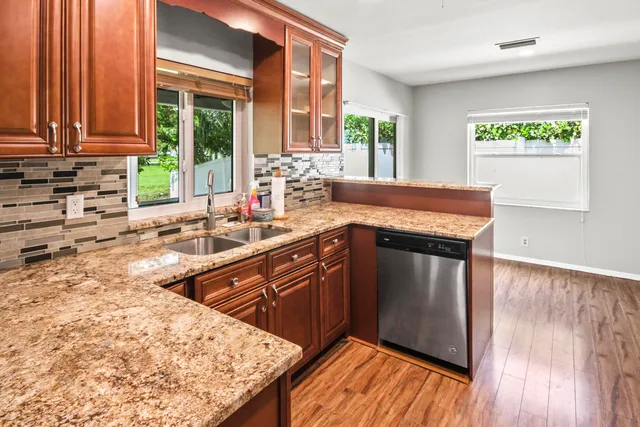 a kitchen with stainless steel appliances granite countertop a sink stove and cabinets