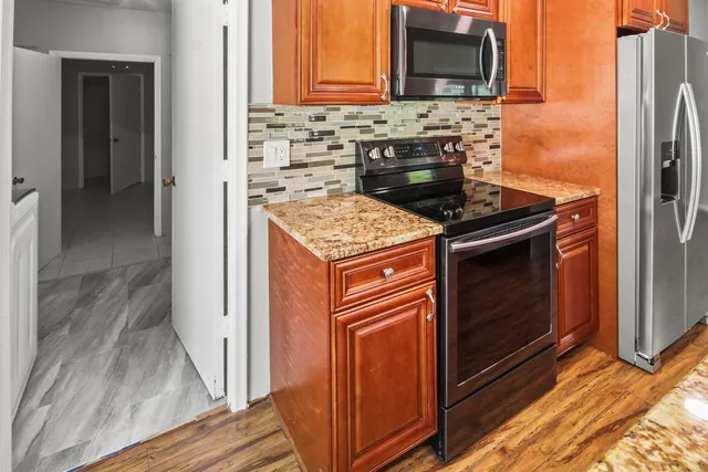 a kitchen with granite countertop a stove and a refrigerator